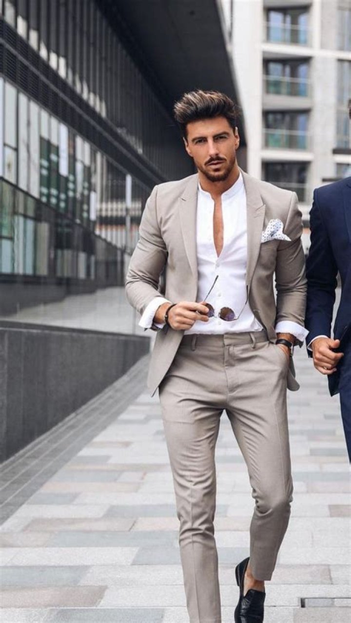 a man in a suit and tie posing for a photo