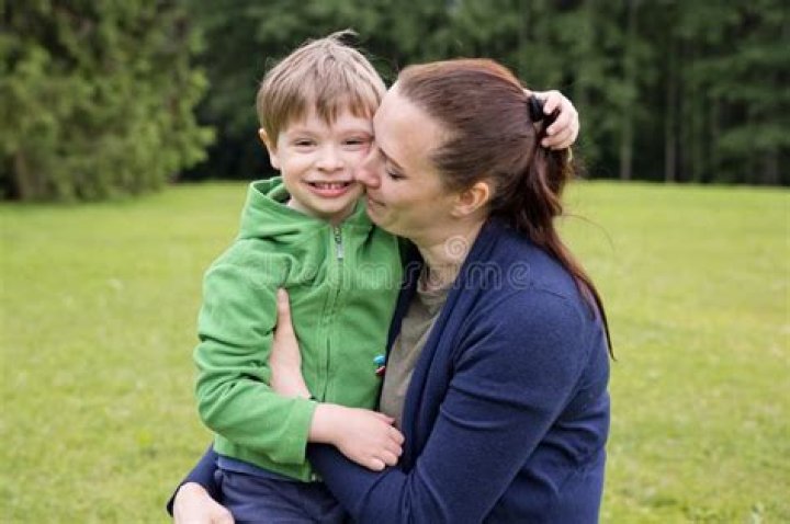 Happy Mom with Son Playing with Soccer Ball on Field, Outdoors Stock
